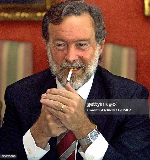 El canciller de Argentina Rafael Bielsa enciende un cigarrillo durante un encuentro con su homologa de Colombia Carolina Barco, el 12 de mayo de 2004...