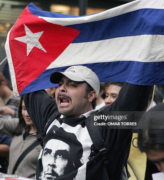 Un hombre levanta la bandera de Cuba durante una manifestacion a favor del pais caribeno en las calles de la ciudad de Mexico, el 12 de mayo de 2004....