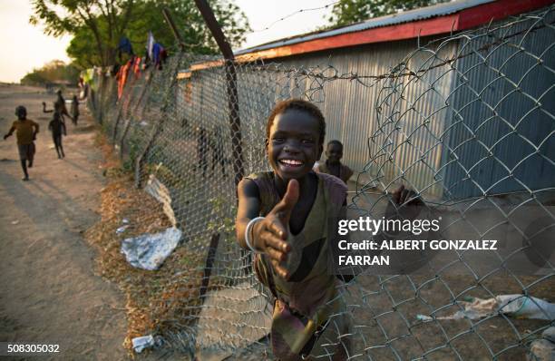 Child climbs through a fence inside the former compound of the International Committee of the Red Cross in the half-emptied village of Leer, South...