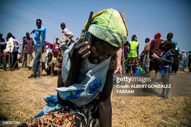 Woman from Thonyor, South Sudan, uses a satellite phone provided by ICRC on February 3, 2016 to call her lost relatives, who fled the village in...
