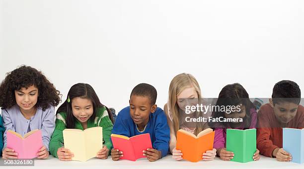 children reading books together - boy yellow shirt stock pictures, royalty-free photos & images