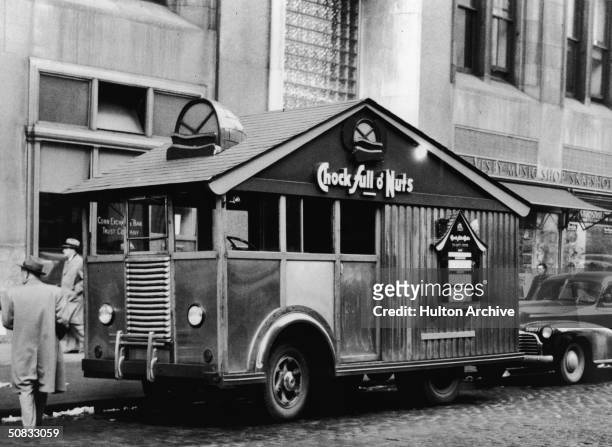 Chock Full o' Nuts' novelty truck, shaped like a cabin with a screened-in porch, parked outside the Corn Exchange Bank Trust Company, New York, New...