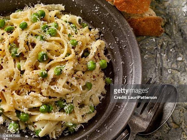 creamy fettucini with peas and parmesan - garlic bread stock pictures, royalty-free photos & images