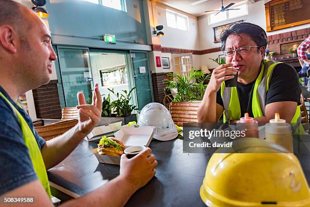 workmen relaxing with beer after work in high visibility clothes - mining worker stock pictures, royalty-free photos & images