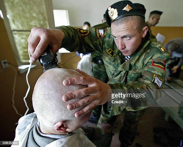 Russian sergeant crops the hair of a young recruit, during a recruitment rally for the Russian army in Kaliningrad, 14 May, 2004. Many Russian...