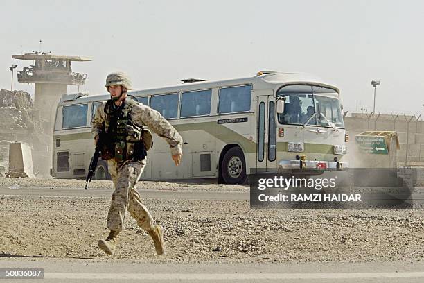 Soldier runs as a bus load of prisoners leaves the Abu Ghraib prison compound in route to an undisclosed location where they were later released14...