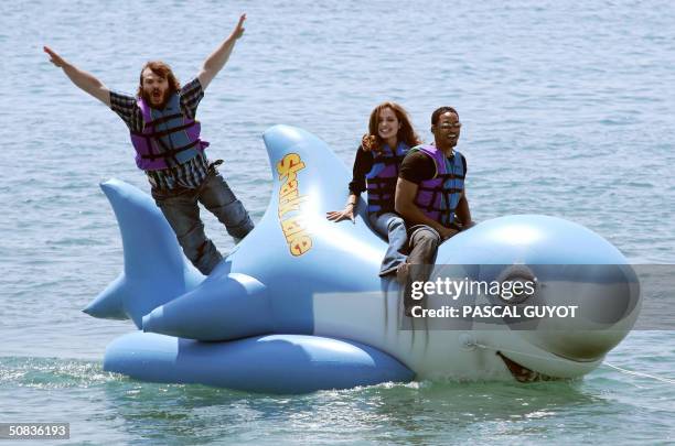 Actor Jack Black jumps into the sea as actress Angelina Jolie and Will Smith ride into shore at the Carlton Hotel beach on a promo float for their...