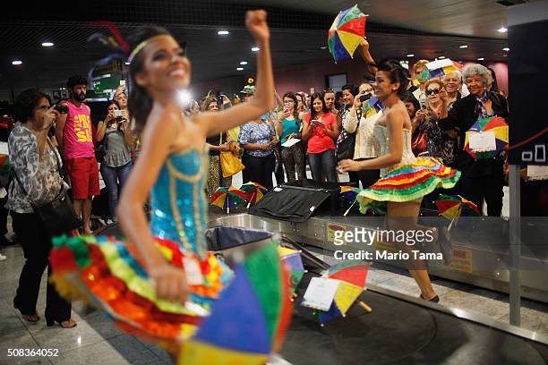 Carnival dancers perform for people arriving in the baggage claim area at Guararapes Gilberto Freyre International Airport on February 4, 2016 in...