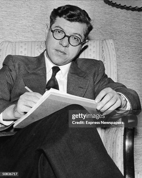 British astronomer, mathematician, and science fiction writer Fred Hoyle sits in a chair with a pen and notepad, February 12, 1958. Hoyle coined the...