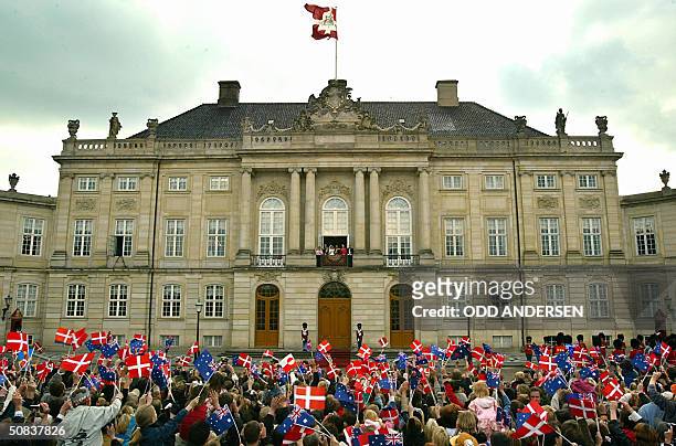 Thousands of wellwishers wave flags at Crown prince Frederik and Crown princess Mary of Denmark standing on the balcony at Amalienborg castle in...