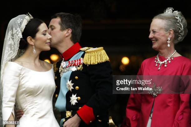 Crown Princess Mary and Crown Prince Frederik kiss as Queen Margrethe II of Denmark looks on as the Royal couple appear on the balcony of Christian...