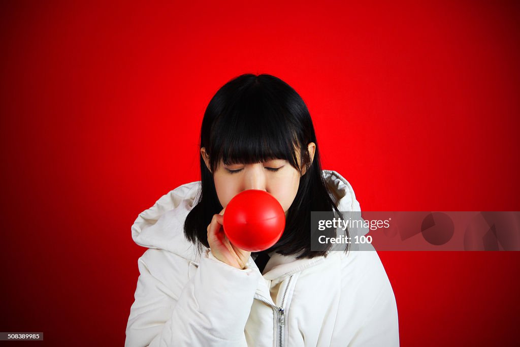 Girl blowing balloon