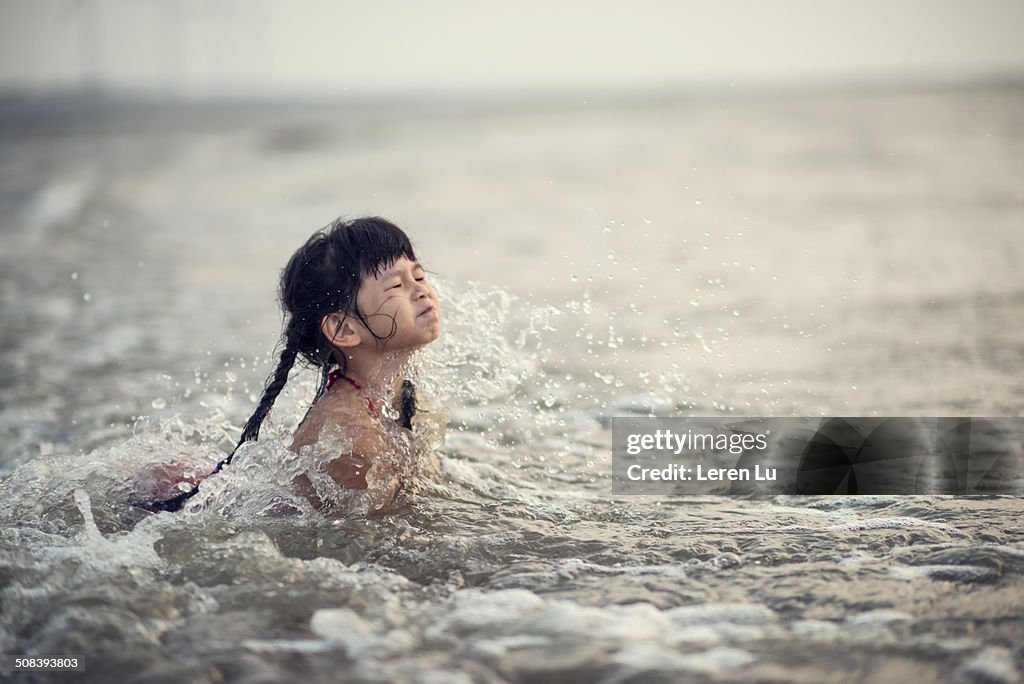 Girl swimming with seawater on face