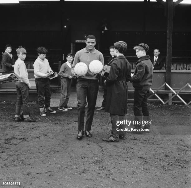 South African footballer Albert Johanneson of Leeds United, with fans at the Hendon Football Club ground, London, during a team training session...