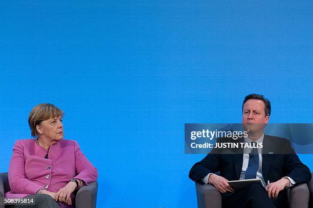 German Chancellor Angela Merkel and British Prime Minister David Cameron sit on stage during a press conference at the QEII centre in central London...