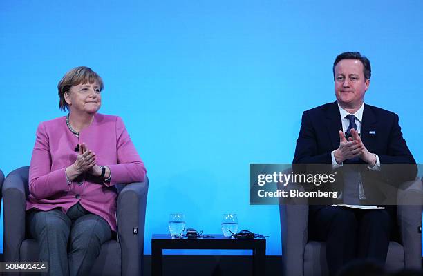 Angela Merkel, Germany's chancellor, left, and David Cameron, U.K. Prime minister, applaud during a news conference at the Supporting Syria 2016...