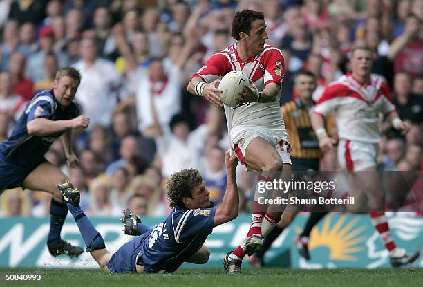 Sean O'Loughlin of Wigan Warriors tries to tackle Lee Gilmour of St. Helens during the Powergen Challenge Cup Final match between St. Helens and...