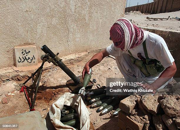 Gunman loyal to radical cleric Moqtada al-Sadr readies a mortar at a position May 15, 2004 in the holy city of Najaf, Iraq. U.S forces and al-Mehdi...