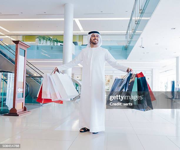 glücklich nahen osten mann mit einkaufen taschen - handsome middle eastern men stock-fotos und bilder