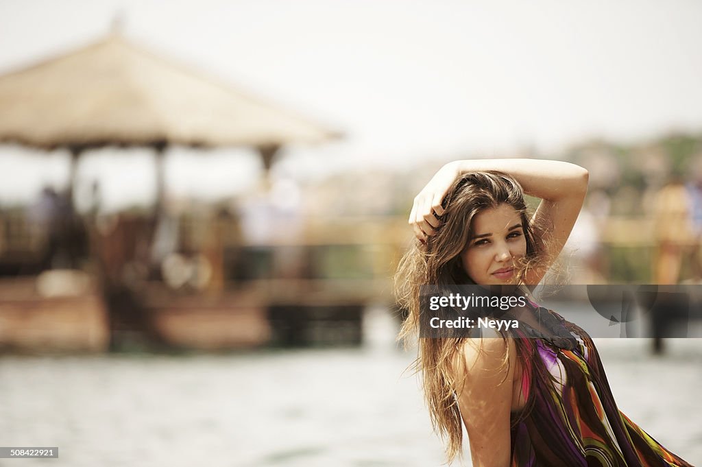 Smiling Young Beautiful Woman Sunbathing on a Beach