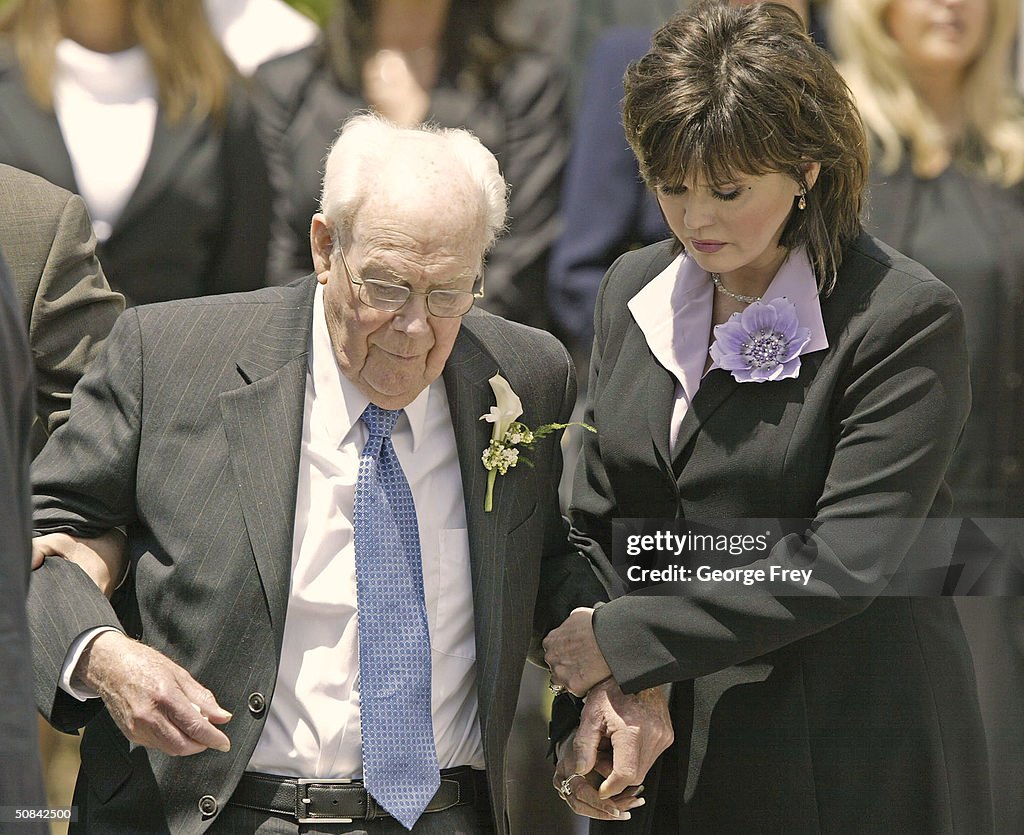 Singer Marie Osmond helps her father George Osmond out of the church