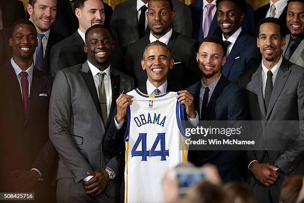 President Barack Obama holds a Golden State Warriors basketball jersey presented to him during an event with the team in the East Room on February 4,...