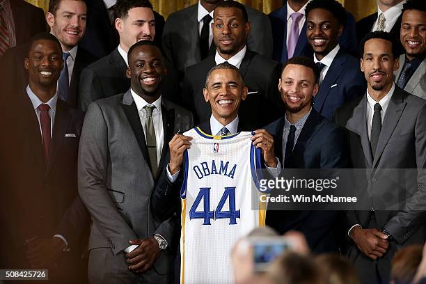 President Barack Obama holds a Golden State Warriors basketball jersey presented to him during an event with the team in the East Room on February 4,...