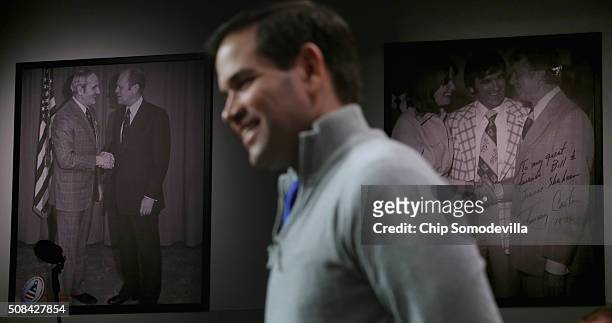 Photographs of former presidents of the United States hang on the wall behind Republican presidential candidate Sen. Marco Rubio as he holds a...
