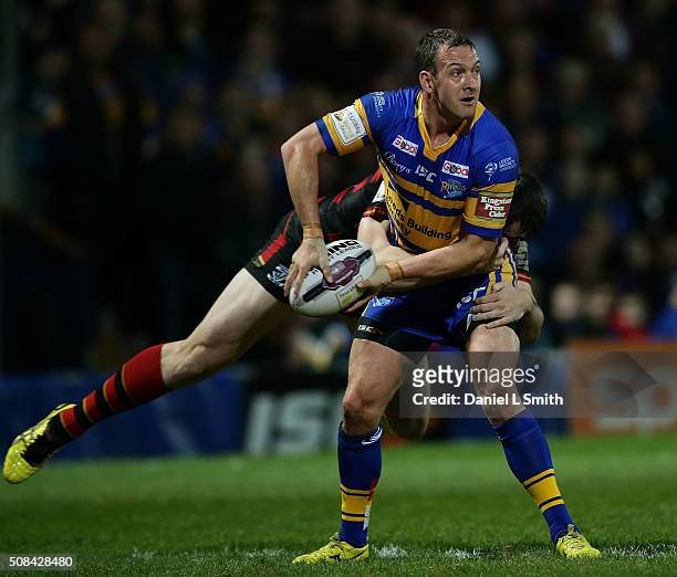 Tom Briscoe of Leeds Rhinos is tackled by Jordan Cox of Warrington Wolves during the First Utility Super League opening match between Leeds Rhinos...