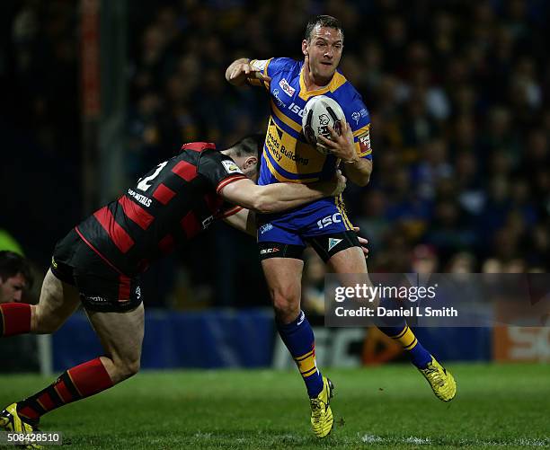 Tom Briscoe of Leeds Rhinos is tackled by Jordan Cox of Warrington Wolves during the First Utility Super League opening match between Leeds Rhinos...