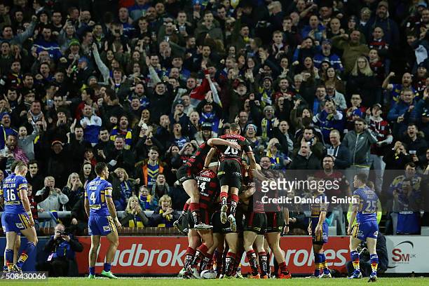 Warrington Wolves celebrate after Chris Sandow scores the opening try of the First Utility Super League opening match between Leeds Rhinos and...