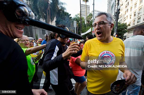 Sao Paulo's Health Secretary, Alexandre Padilha , dances with two revellers dressed as mosquitos during a street carnival in the Brazilian city of...