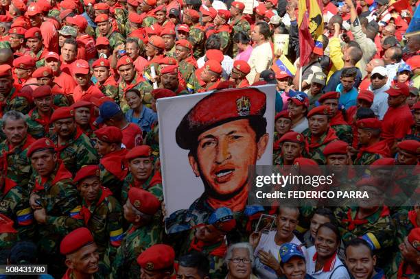 Soldiers holds a portrait of late Venezuelan President Hugo Chavez during a ceremony to commemorate the 24th anniversary of Chavez's military coup...