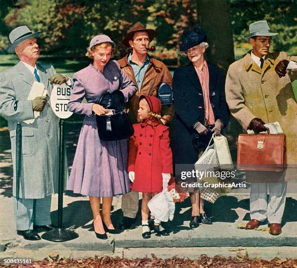 View of a group of white Americans waiting for a bus at a bus stop in a small town, 1952. Screen print.