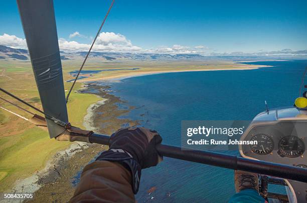 hang glider over longufjorur coastline - hang glider stock pictures, royalty-free photos & images