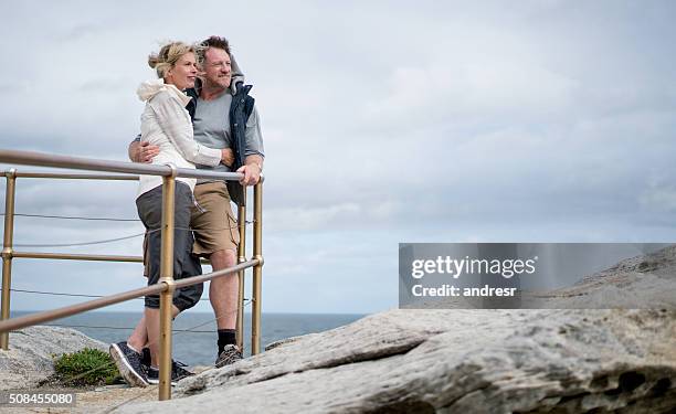 adult couple taking a walk by the beach - winter australia stockfoto's en -beelden