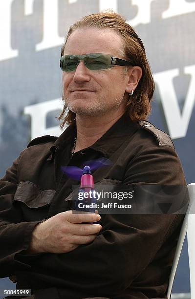 S Bono cools down with a fan at the launch of The "One" Campaign to Fight Global Aids and Poverty May 16, 2004 in Philadelphia, Pennsylvania....
