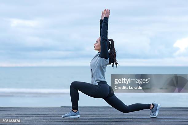 schöne brünette frau auf einem strand trägt sport kleidung - alluring fitness stock-fotos und bilder