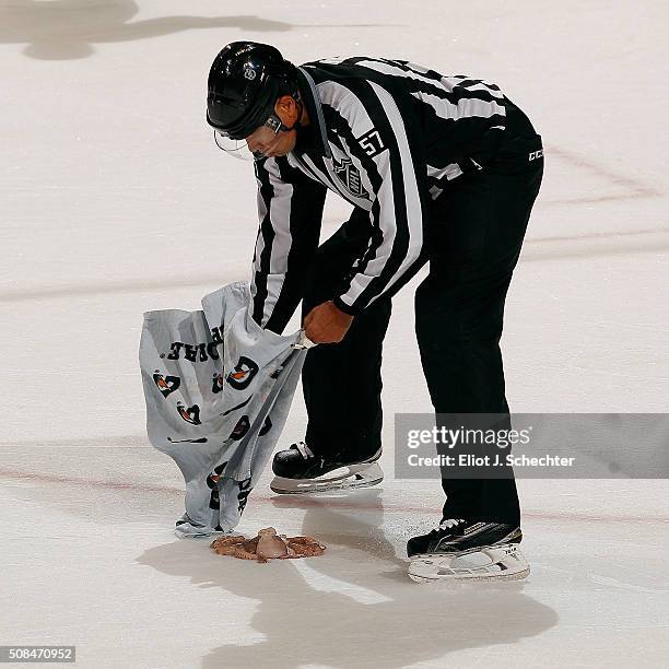 Linesmen Jay Sharrers scoops up a octopus during a break in the action between the Detroit Red Wings and the Florida Panthers at the BB&T Center on...