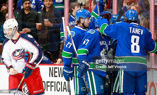 Ben Hutton, Sven Baertschi and Christopher Tanev of the Vancouver Canucks congratulate goal scorer Linden Vey of the Vancouver Canucks while Cody...