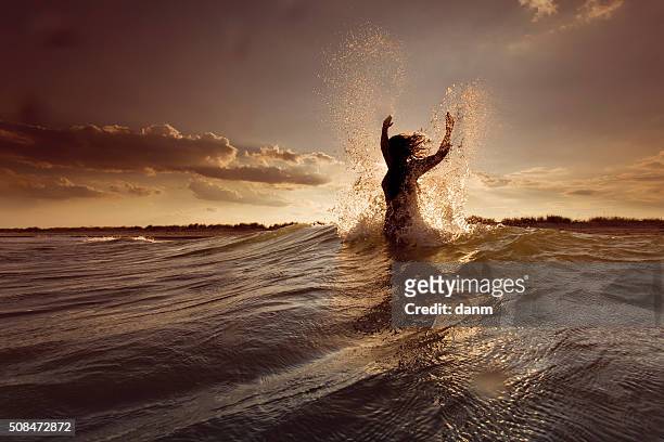 young woman on sea embracing the the world and the waves - strand of human hair stock pictures, royalty-free photos & images