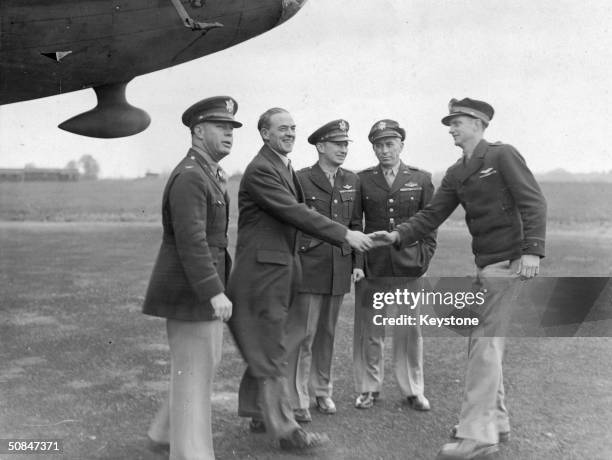 Sir Stafford Cripps, British Minister of Aircraft Production, shakes hands with Captain Robert K Morgan, pilot of the Memphis Belle during a visit to...