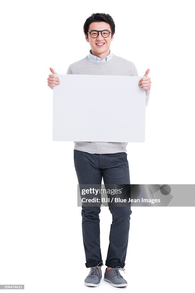 Cheerful young man holding whiteboard