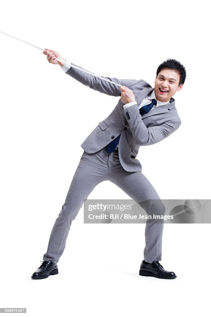 Excited businessman pulling rope