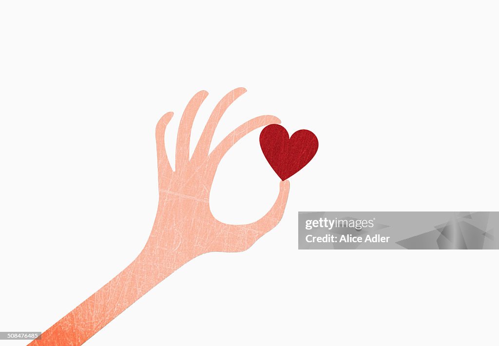 A hand holding heart shape against white background