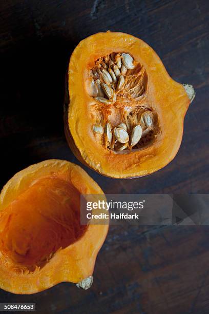high angle view of kuri squash halves on table - hokaido pumpkin stock pictures, royalty-free photos & images