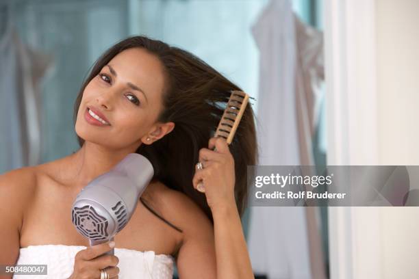 indian woman blow drying her hair - brushing photos et images de collection