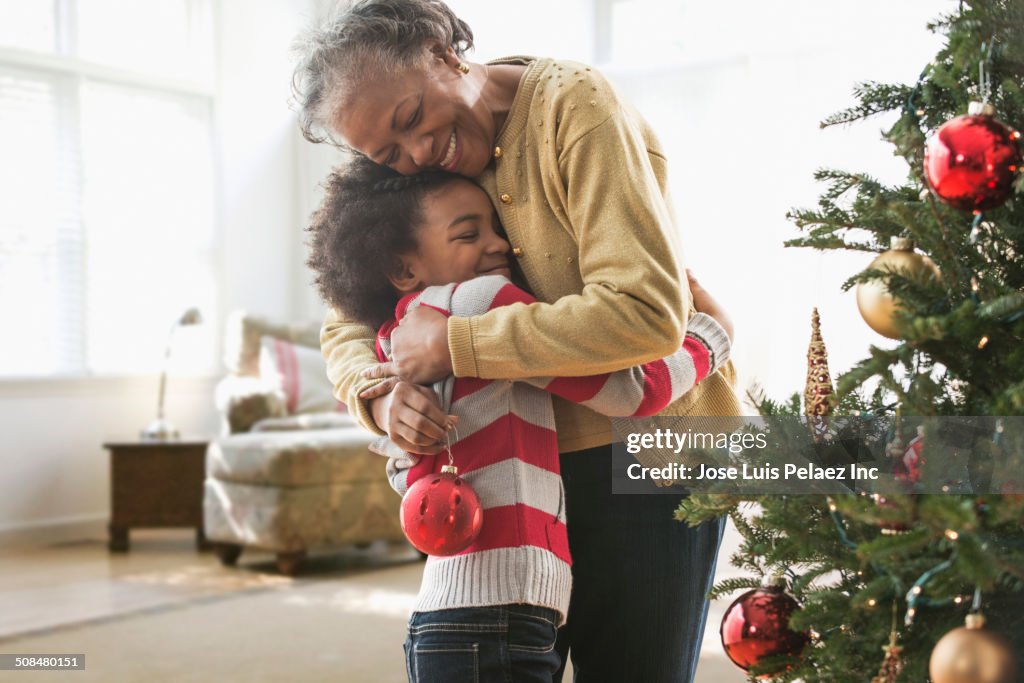 Older woman and granddaughter decorating Christmas tree