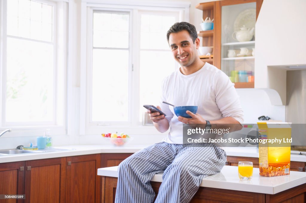 Indian man eating breakfast on kitchen counter