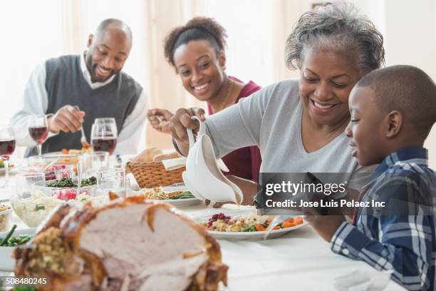 family eating together at holiday table - sugo di carne foto e immagini stock